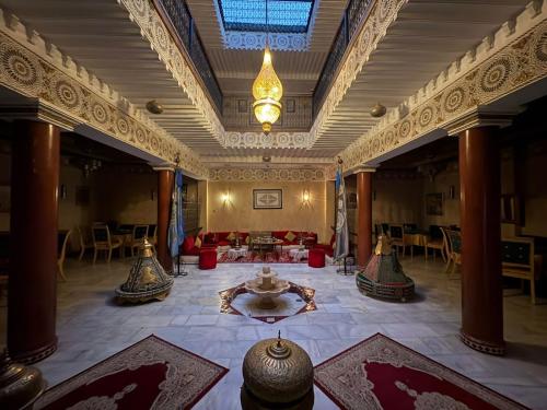 a large room with a fountain in the middle of a building at Riad Golf Stinia 1 in Meknès