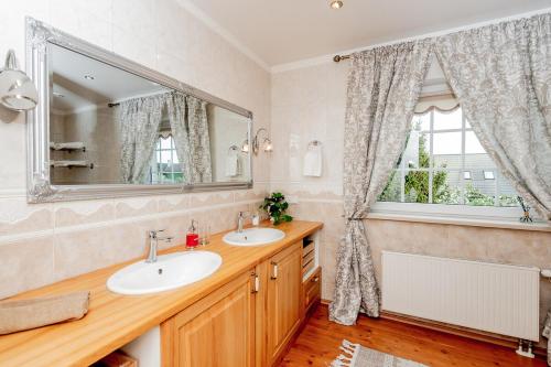 a bathroom with two sinks and a large mirror at Luxury Villa in Pärnu, walking distance from the beach and city centre in Pärnu