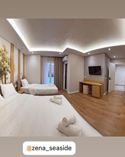 une chambre d'hôtel avec deux lits et une télévision dans l'établissement Zena Seaside Durres, à Durrës