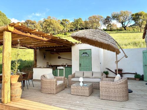 patio con sedie in vimini e ombrellone di Ì Caseddi dì Bergerie Anto'Micheli a Granace