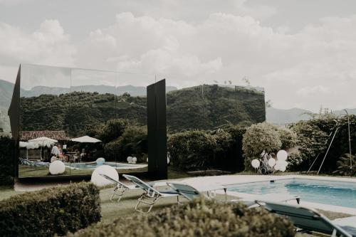 a resort with a pool and chairs and a mountain at Mirror Houses in Bolzano