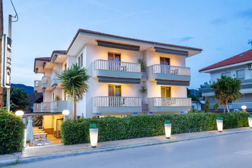 a building with palm trees in front of a street at Garden in Limenaria