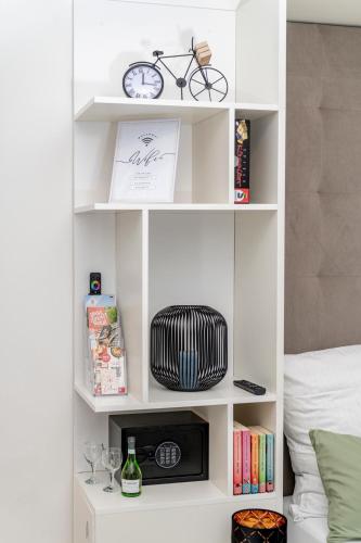 a white book shelf with a bike on it at Danube Rooms - Self Checkin - Küche in Passau