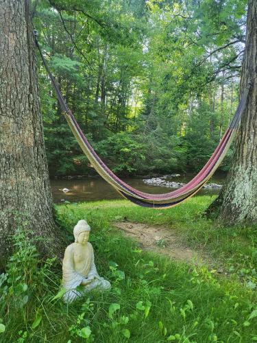 aitatingitating woman sitting in the grass next to a hammock at Godspeed Events and Lodging in Port Matilda
