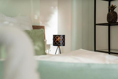 a bedroom with a white bed and a lamp at Danube Rooms - Self Checkin - Küche in Passau