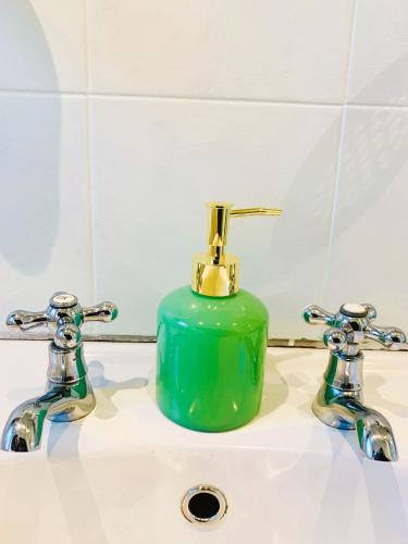 a green soap dispenser sitting on top of a bathroom sink at Anamcara Villa 3, Natal Midlands Balgowan in Balgowan