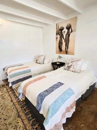 two beds in a bedroom with a painting on the wall at Anamcara Villa 3, Natal Midlands Balgowan in Balgowan