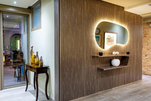 a room with a wall with a mirror and a table at Garden in Limenaria