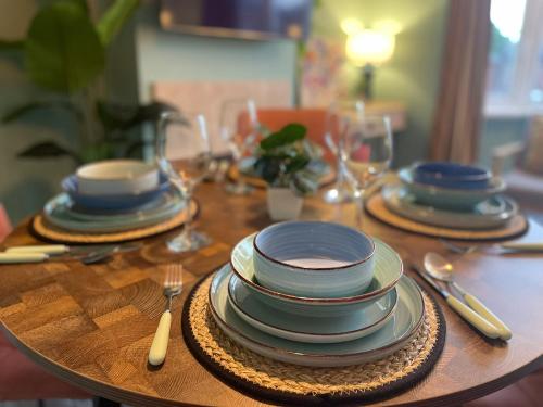 a wooden table with plates and utensils on it at The Vinyl, 1 bed flat near Southampton Uni in Southampton