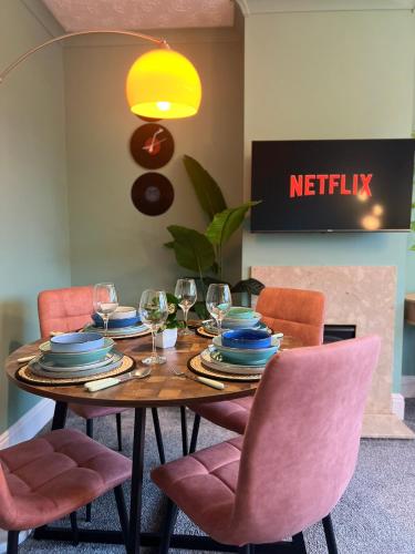 a dining room table with chairs and wine glasses at The Vinyl, 1 bed flat near Southampton Uni in Southampton