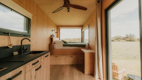 a kitchen in a tiny house with a large window at Parcel Tiny House Ty Pois 2 près de la Pointe de La Torche in Plonéour-Lanvern