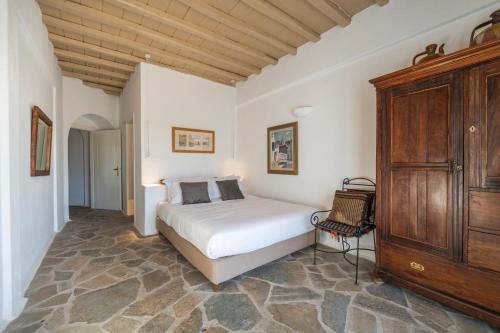 une chambre avec un lit et une armoire en bois dans l'établissement Villa Ipanema with Private Beach by Mykonos Mood, à Mykonos