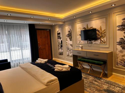 Un dormitorio con una cama con un escritorio y un televisor. en Hayat Rose Apart, en Uzungöl