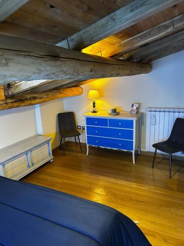 a room with a blue dresser and two chairs at Chalet Il Ballatoio in Rocca di Botte