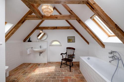 a bathroom with a bath tub and a chair at Landhaus Wusse Ferienwohnung Hiddensee in Ummanz