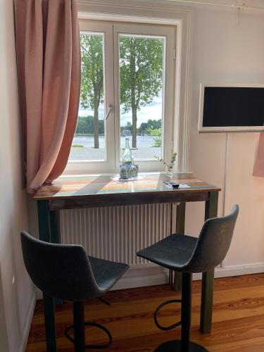 a desk with two chairs in front of a window at Burger Fährhaus in Burgerfeld