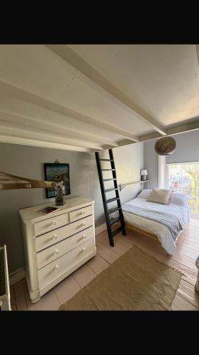 a bedroom with a bed and a ladder and a dresser at Beautiful, airy flat with Park views in Leamington Spa