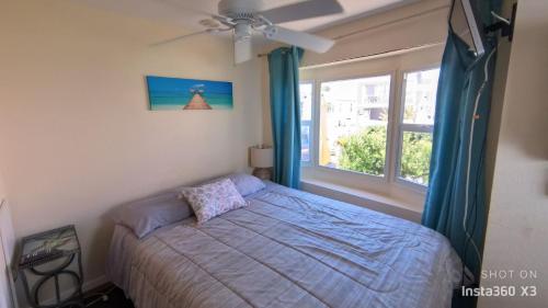 un dormitorio con una cama y una ventana en N326 adorable 2 b 2 ba beach bungalow Located on Nettles Island FL, en Jensen Beach