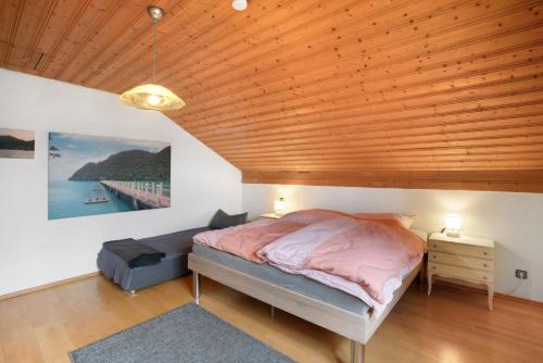 a bedroom with a bed and a wooden ceiling at Ferienwohnung Dorfidyll in Jesenwang