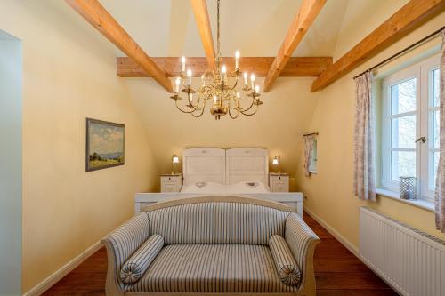 a living room with a chair and a chandelier at Landhaus Trent Haushälfte Breetz in Trent