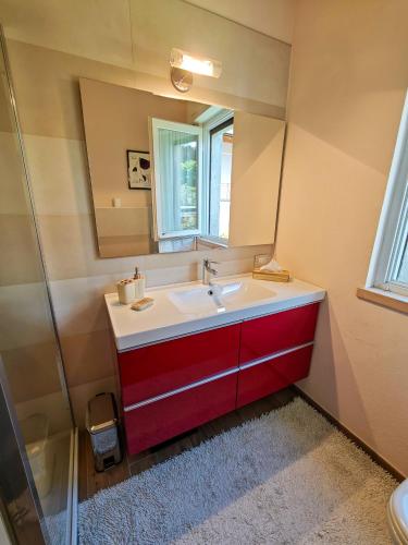 a bathroom with a red sink and a mirror at Pianoforte in Gravedona