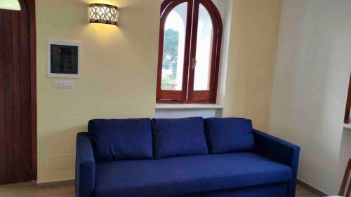 a blue couch in a living room with a window at Villa Rosalba Holiday in San Nicola