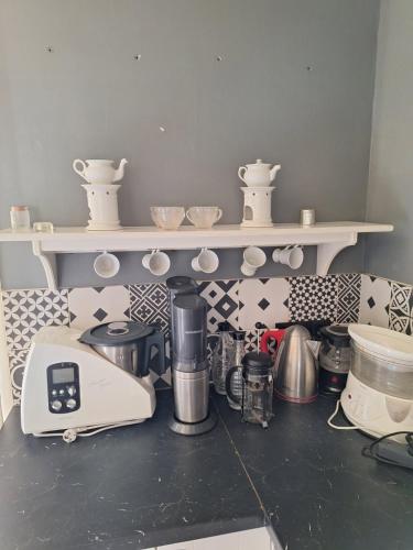 - un comptoir de cuisine avec un grille-pain et des tasses sur une étagère dans l'établissement La Grange, gîte de campagne proche Benon et La Rochelle, à Saint-Georges-du-Bois