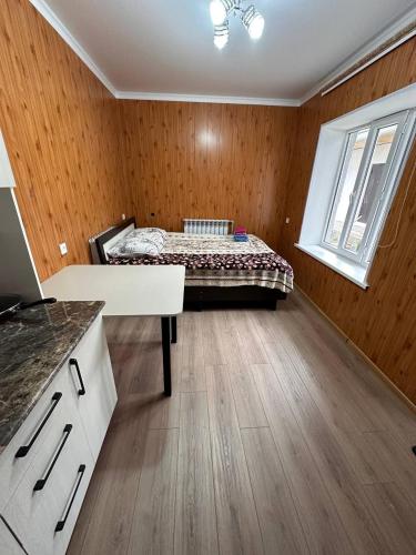 a bedroom with a bed in a room with wooden walls at Pamko in Naryn
