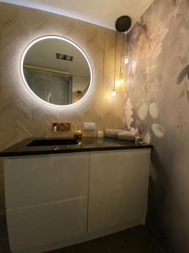 a bathroom with a sink and a mirror at Apartament MoLoo I in Ostróda
