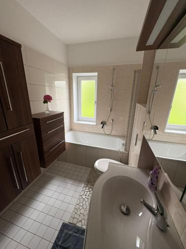 a bathroom with a sink and a tub and a toilet at Landhaus Eugenie in Garmisch-Partenkirchen