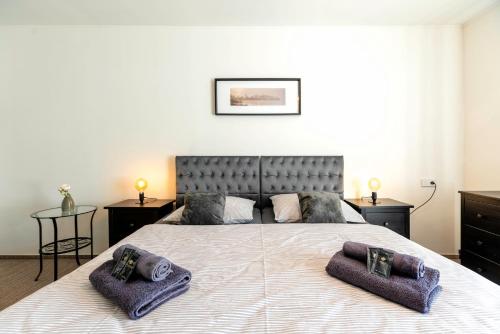 a bedroom with a large bed with purple towels on it at Restaurace Hotel Praha in Nižbor