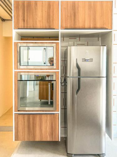 a kitchen with a stainless steel refrigerator and wooden cabinets at Rio Bem-te-vi in Rio de Janeiro