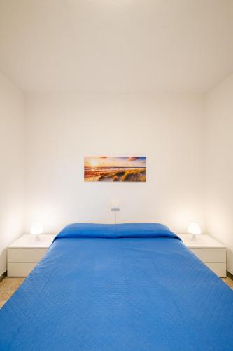 a bedroom with a blue bed and two night stands at Bungalow bei Emma in Cavallino-Treporti