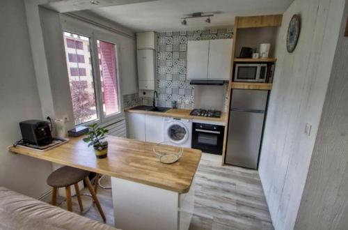une petite cuisine avec une table en bois dans une pièce dans l'établissement La perle du lac, à Thonon-les-Bains