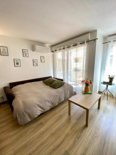 une chambre avec un grand lit et une table dans l'établissement Le Spot Niçois, à Nice