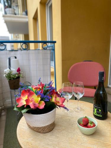 a table with two wine glasses and a vase with flowers at Le Spot Niçois in Nice
