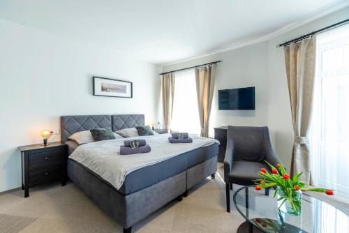 a bedroom with a bed and a chair and a window at Restaurace Hotel Praha in Nižbor