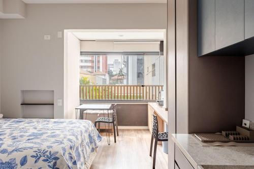 a bedroom with a bed and a table and a balcony at Studio espaçoso- Vl Clementino in Sao Paulo