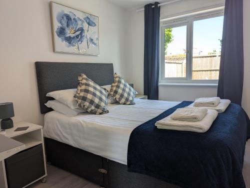 a bedroom with a bed with pillows and a window at Turnstone Bungalow in Hunstanton