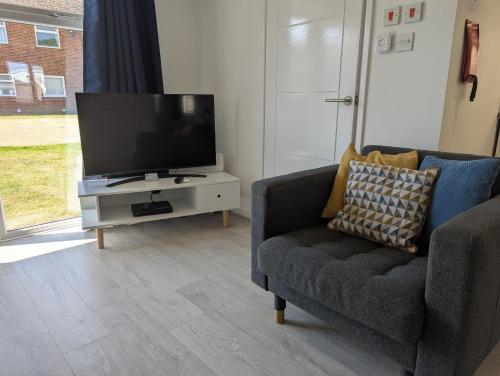 a living room with a tv and a couch at Turnstone Bungalow in Hunstanton