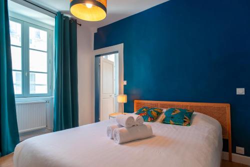 - une chambre bleue avec un lit et des serviettes dans l'établissement Le Closmadeuc - Coeur de ville, à Vannes