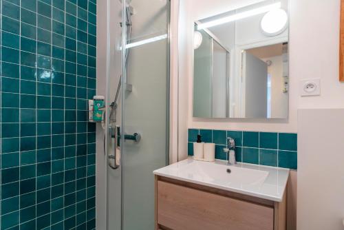 une salle de bain avec un lavabo et une douche dans l'établissement Le Closmadeuc - Coeur de ville, à Vannes