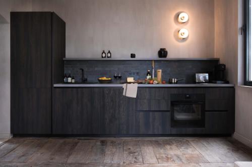 une cuisine avec des armoires noires et un comptoir dans l'établissement Maison proche St Emilion - Luxe, à Abzac