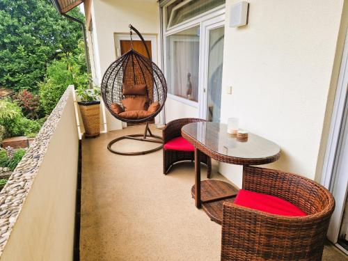 a porch with a swing and a table and chairs at Freiburg citynah - hell, ruhig, gemütlich in Freiburg im Breisgau