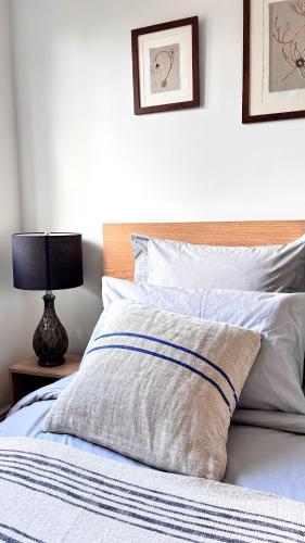 a bed with a pillow and a lamp on a table at Apsley Guest Rooms in Hemel Hempstead