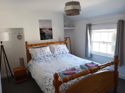 1 dormitorio con cama de madera y almohadas azules y blancas en Patrick's Bar, en Bangor