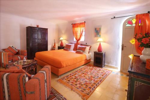 a bedroom with a bed and a living room at Le Bled Ferme in Marrakech