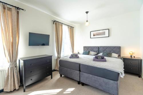 a bedroom with a bed and a tv on the wall at Restaurace Hotel Praha in Nižbor