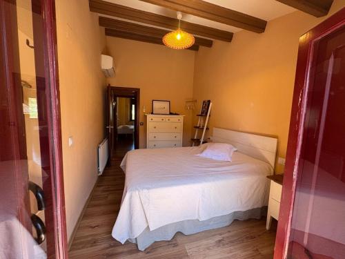 a bedroom with a bed and a dresser in a room at Refugi de l'Albera in Vilamaniscle