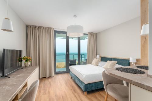 ein Schlafzimmer mit Bett und Blick auf das Meer in der Unterkunft Jantaris - City Apartments in Mielno